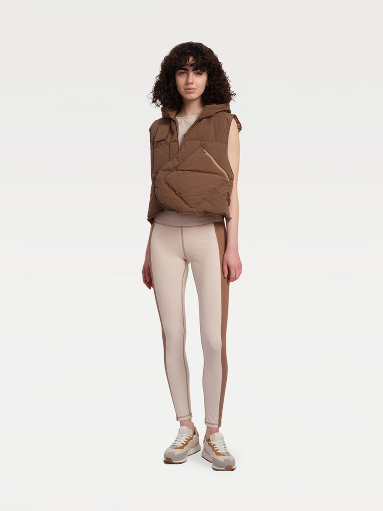 A female model standing in a brown paded vest