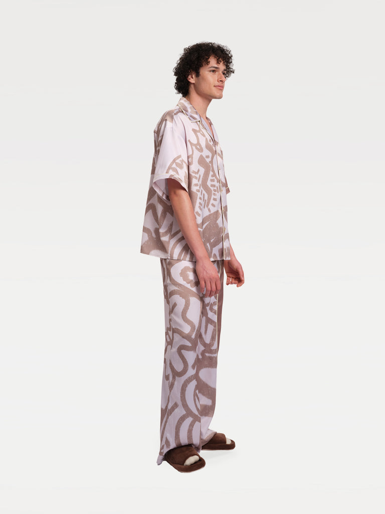 a male model standing sideways in a pajama match set 
